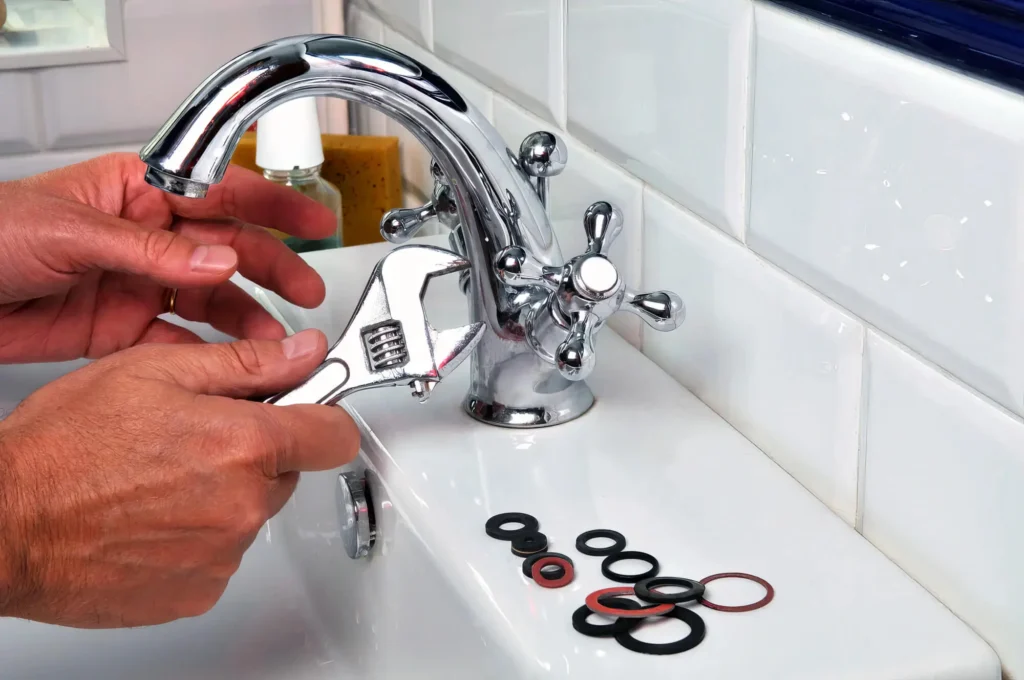 Plumber performing maintenance on a bathroom faucet in Loveland