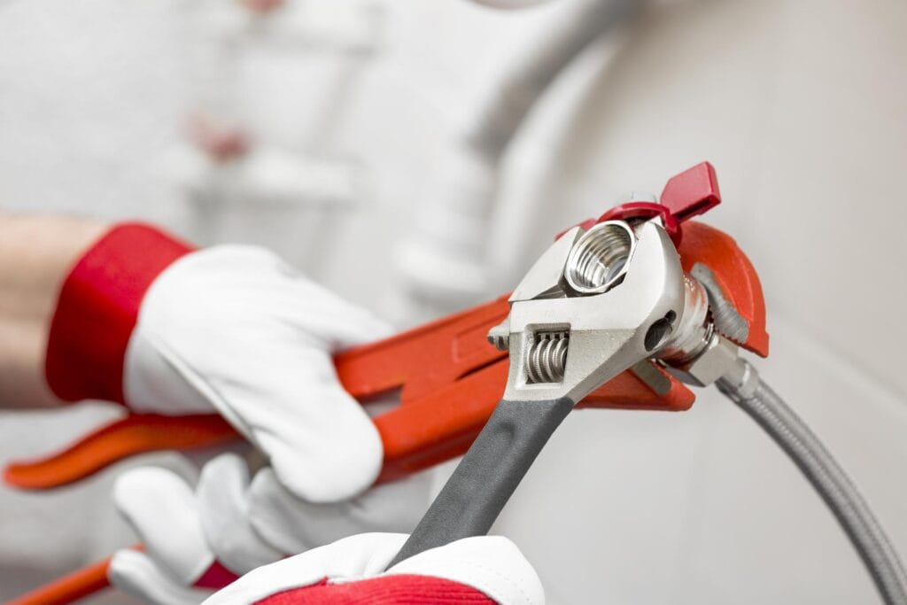 Plumber holding pipe wrenches for an emergency repair in Loveland