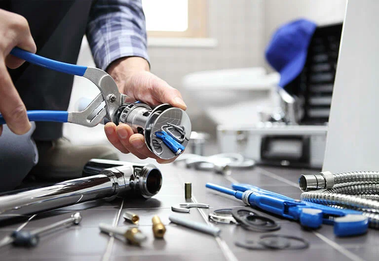 Technician repairing a plumbing fixture with professional tools in Loveland