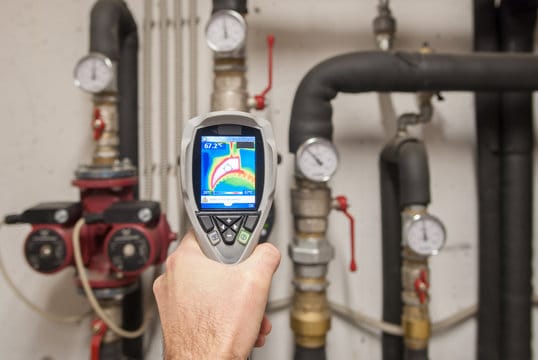 Plumber using a thermal imaging camera to inspect pipes in Loveland