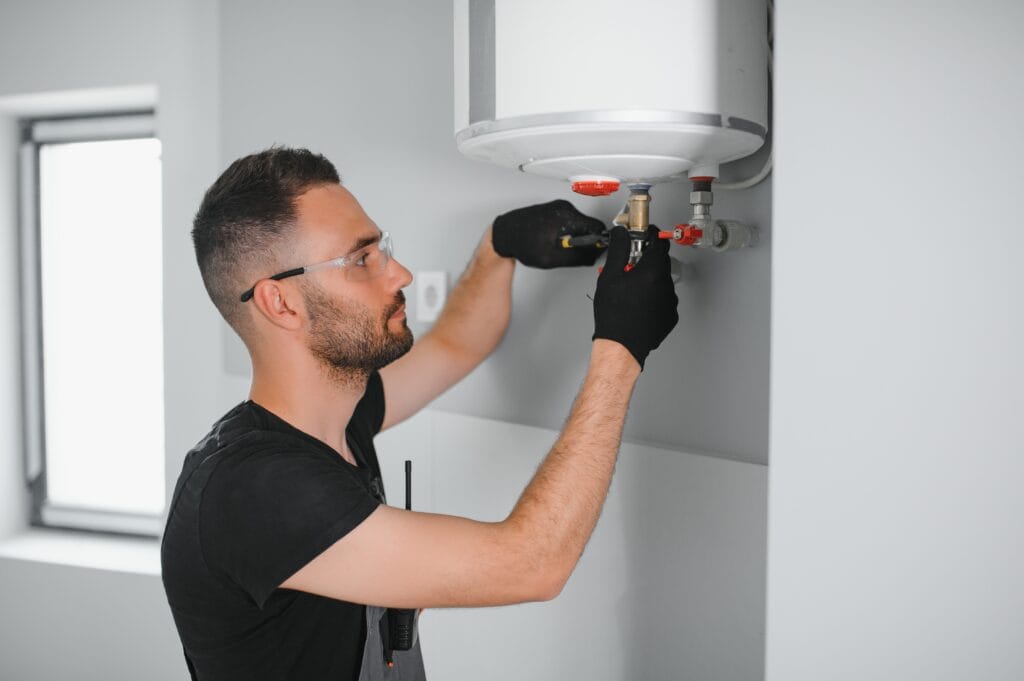 Technician performing water heater maintenance in Loveland