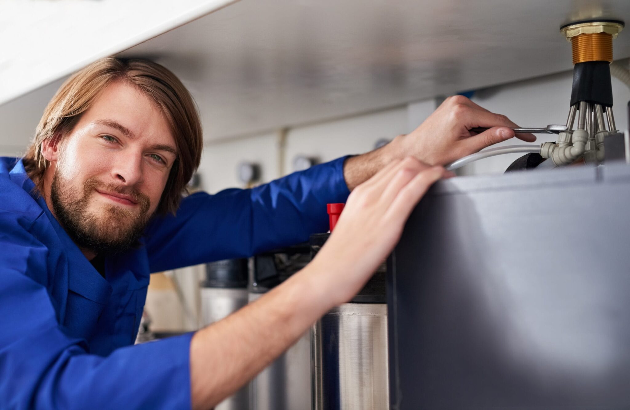 Technician servicing a residential water heater tank in Loveland