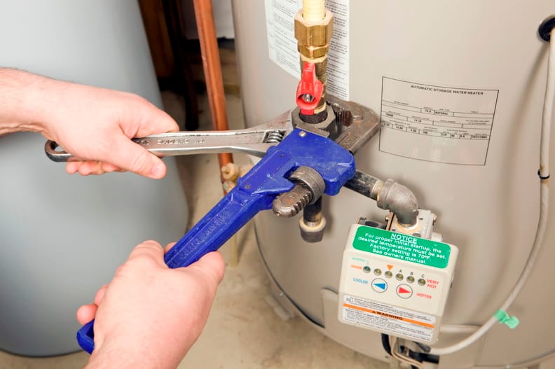 Plumber repairing a water heater valve in Loveland